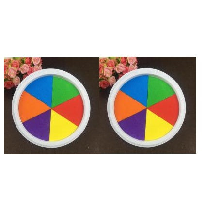 Two colorful wheel-shaped objects with a rainbow pattern on a dark surface.