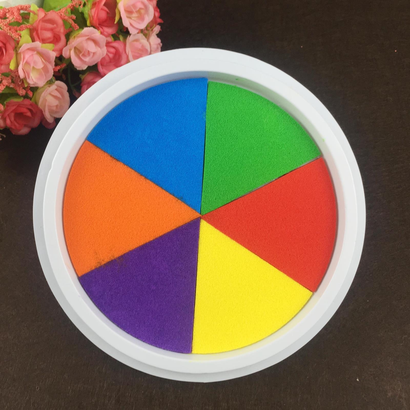 Colorful circular puzzle toy with six sections on a dark surface.