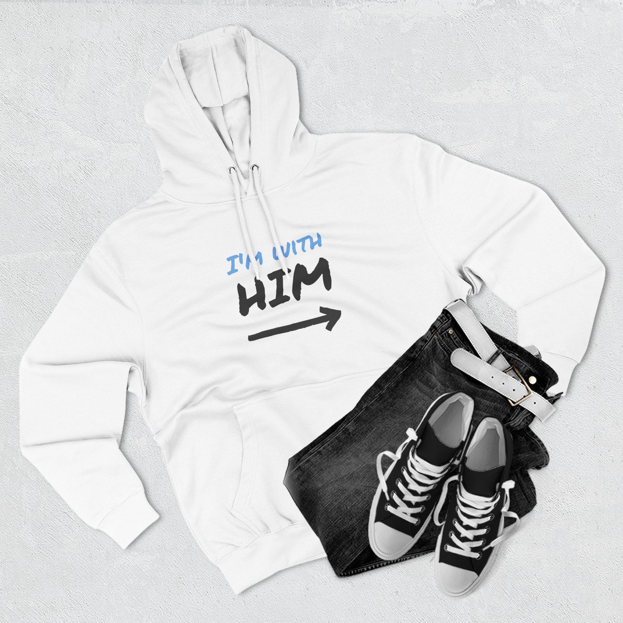 White hoodie with 'Still Got Flex Appeal' text and skeleton graphic, black jeans, and black sneakers on a light gray background.