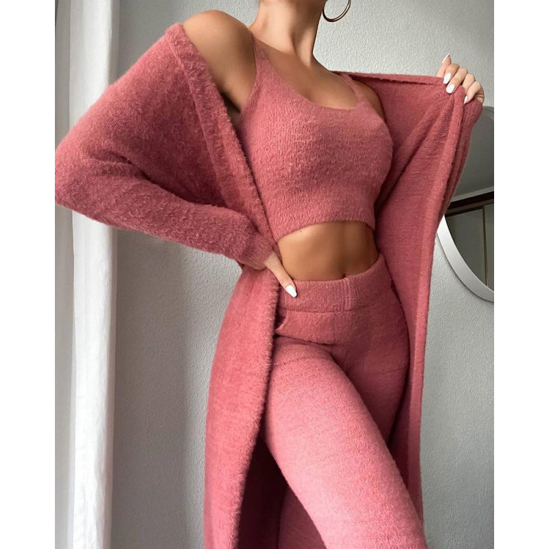 Person wearing a pink outfit with a matching coat against a neutral background