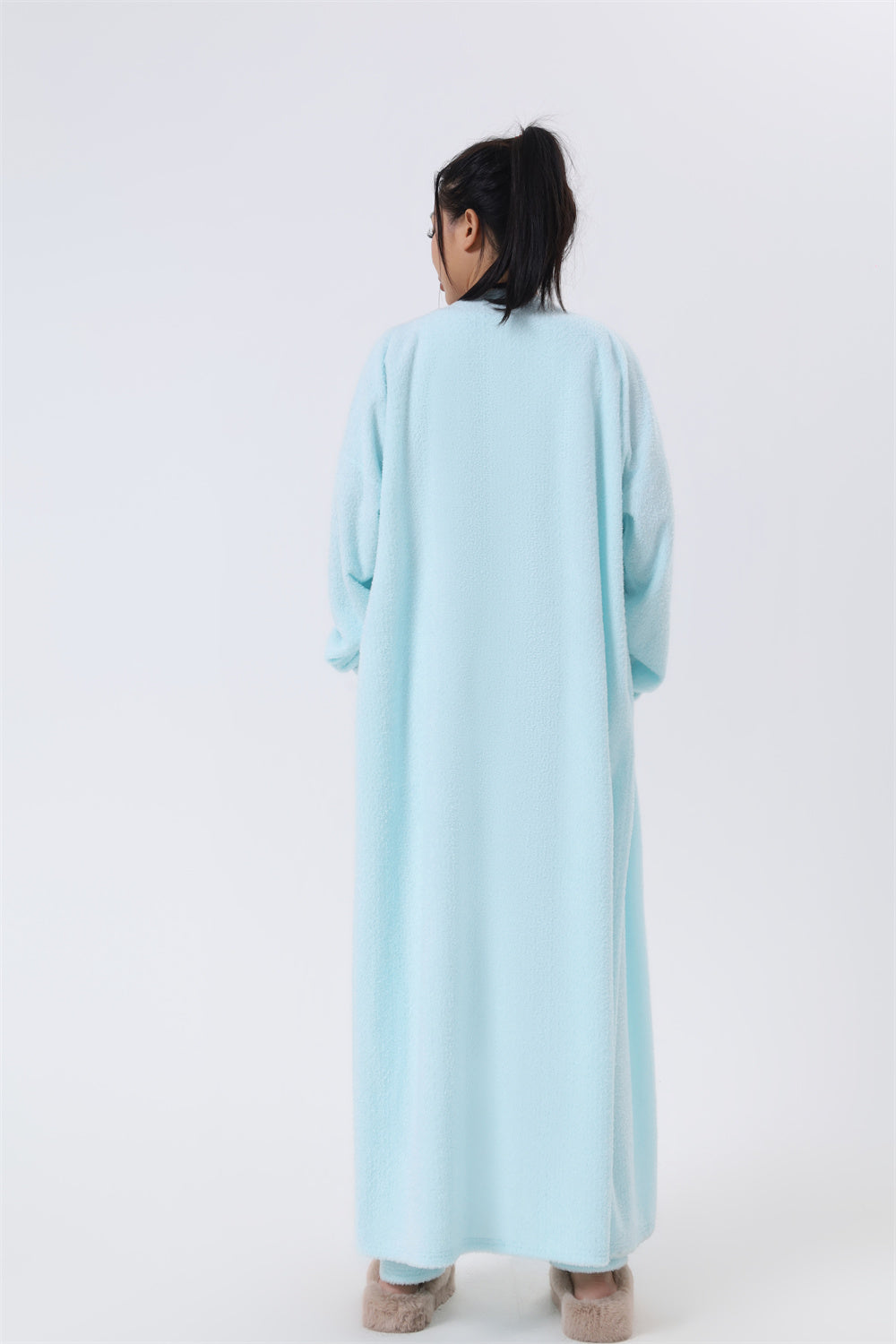 Person wearing a light blue dress against a white background